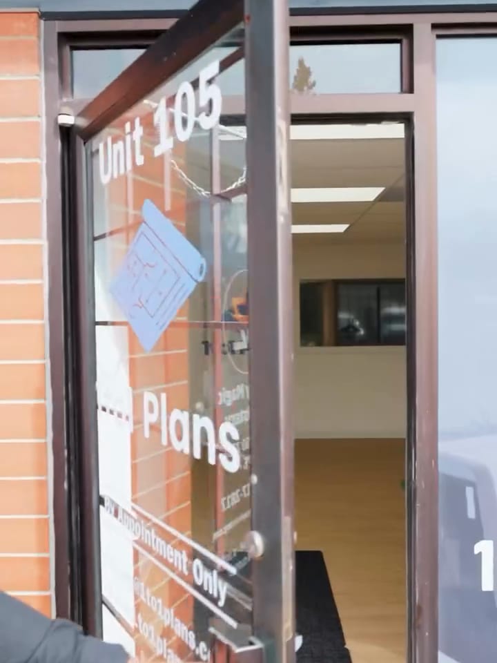 The glass door of Unit 105 marked 1to1 Plans, by appointment only