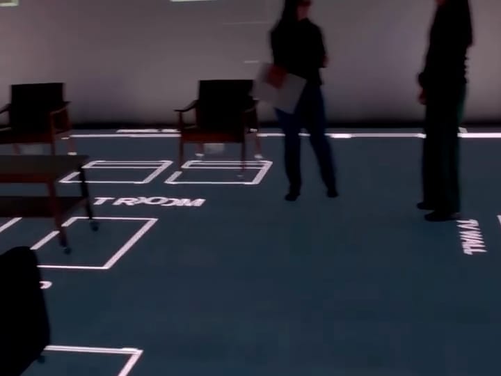 A Trickle Creek Homes walkthrough: people standing inside a client's plan, with the full floor plan on the wall above