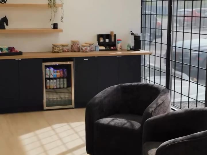 The studio's front lounge with two armchairs, a coffee bar and large windows