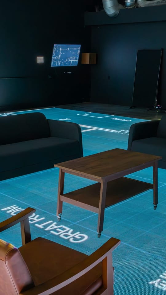 Studio furniture set out on a floor plan glowing on the LED floor