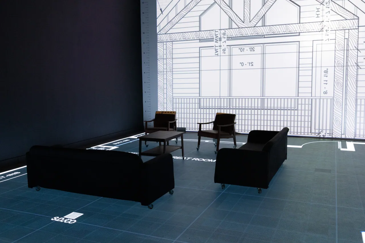 A view across the furnished studio floor toward the elevation screen
